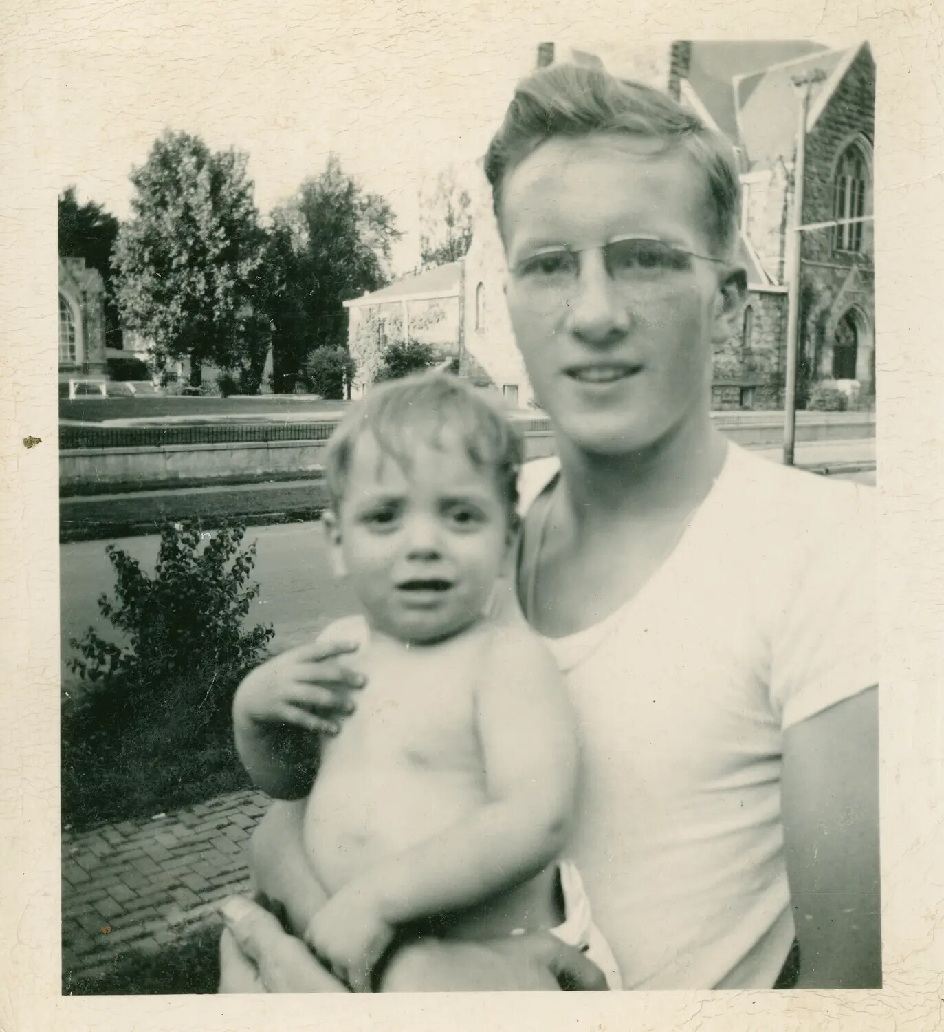 Family Snapshot of a Young Man and Infant Outside a Stone Church — Margaroli Family Album, Postwar Era
