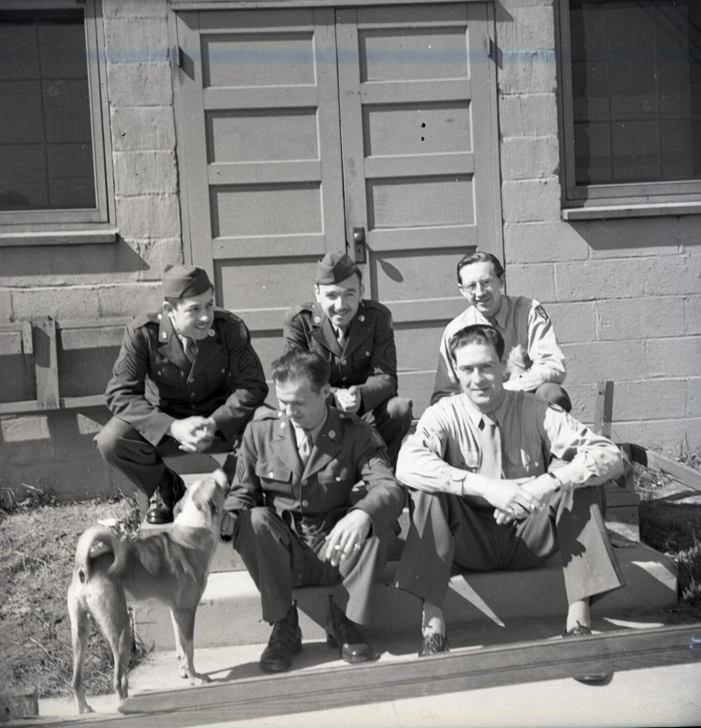 Group Portrait of U.S. Army Enlisted Men (Bandsmen) Outside Barracks Building, with Dog