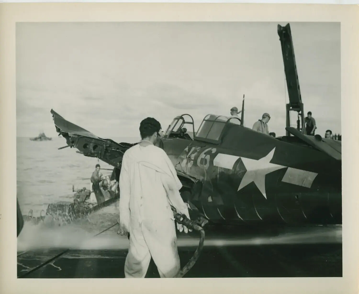 Damaged U.S. Navy Fighter Aircraft Being Hosed Down on Flight Deck, USS Petrof Bay (CVE-80), WWII Pacific Theater