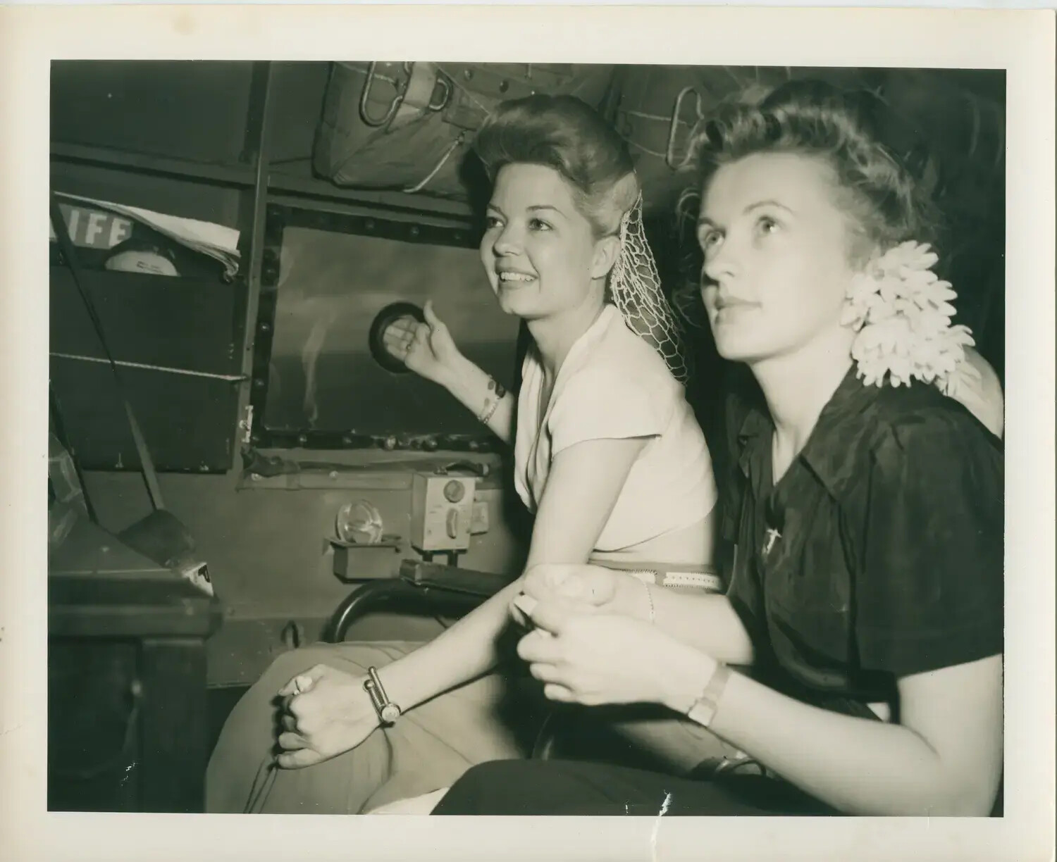 Two Women Seated in Aircraft Turret Interior, USS Petrof Bay (CVE-80) Collection, WWII Era