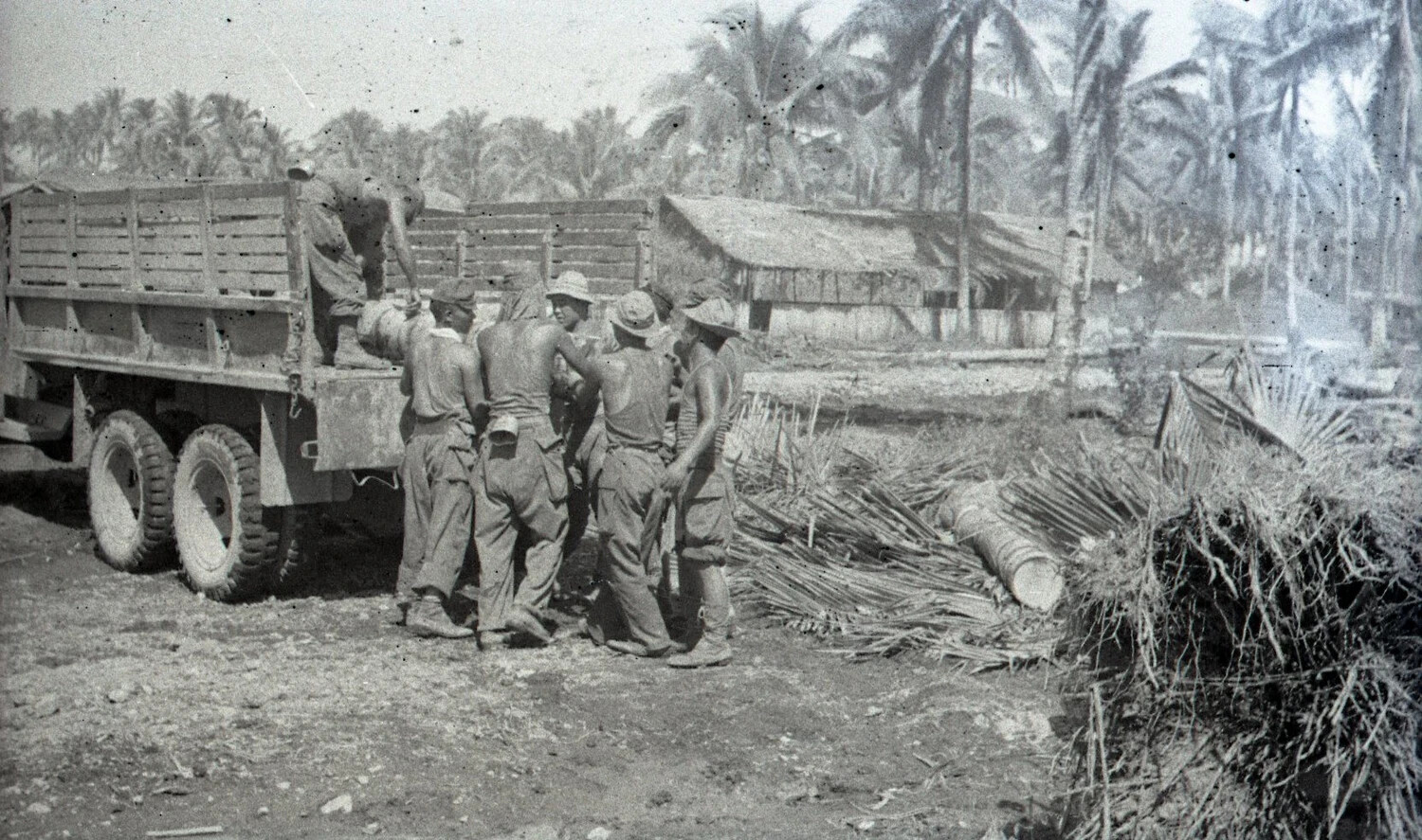 Filipino Laborers Loading Drum onto U.S. Army Truck, Luzon, Philippines, World War II Era