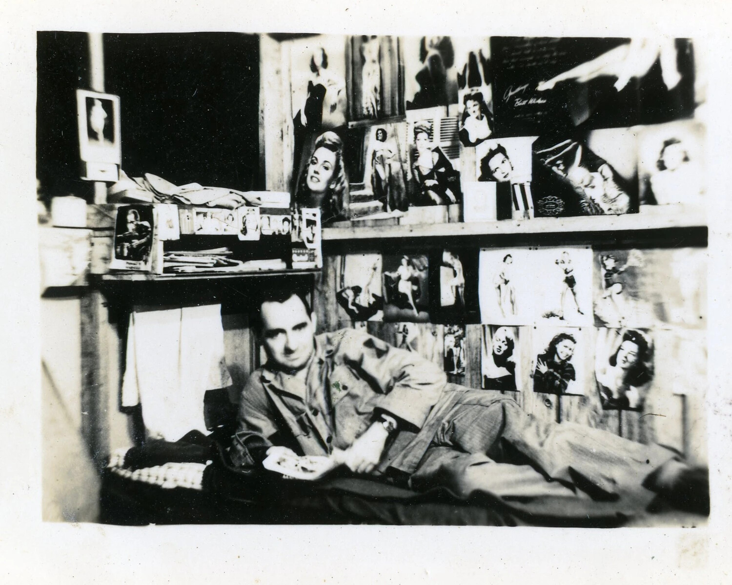 Serviceman Reclining on Bunk Beneath Wall of Pin-Up Photographs, WWII Era