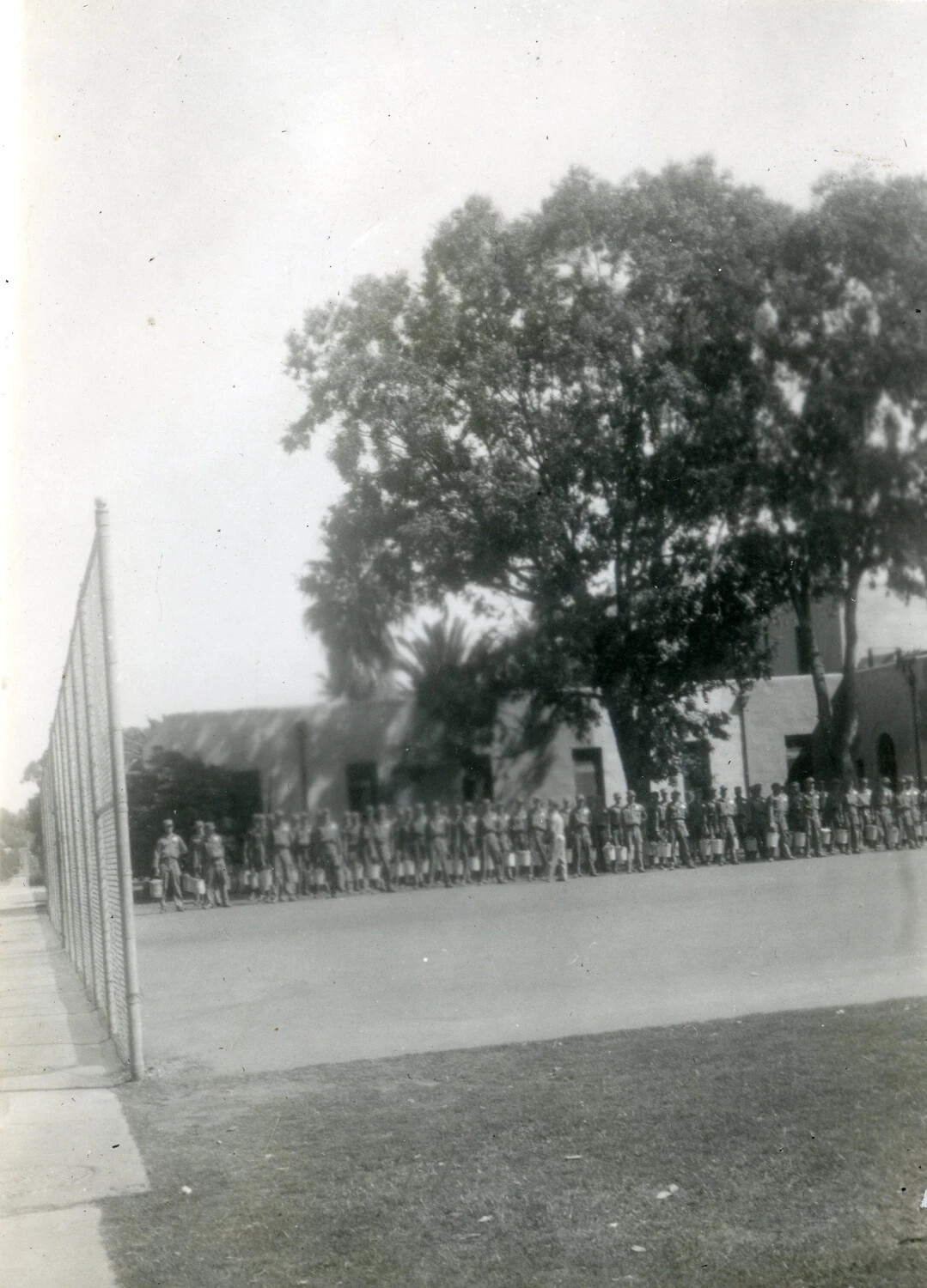 Marines in Formation Holding Cups Outside Barracks Buildings, VMF-214 Album, 1945