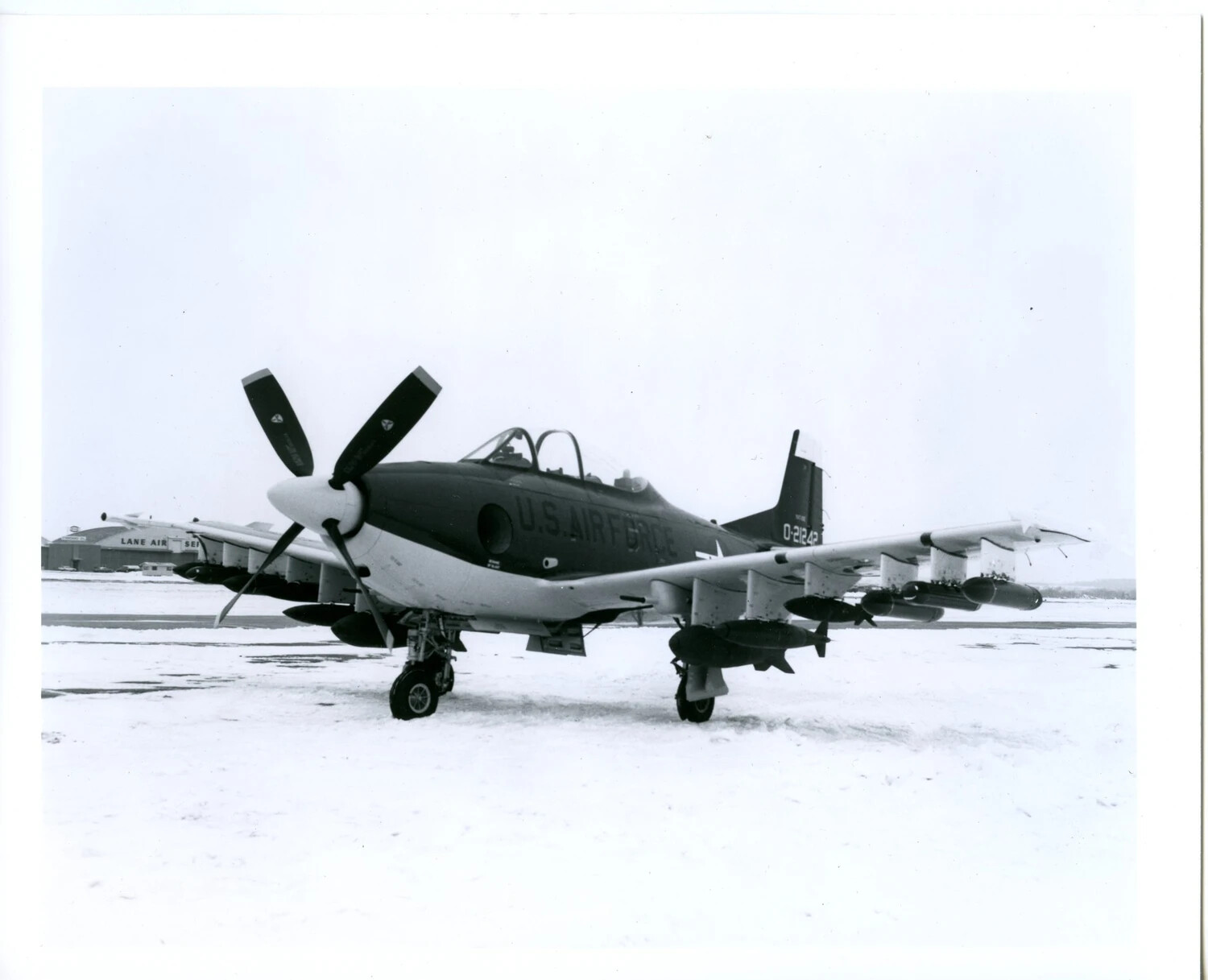 North American F-51D Mustang (Two-Seat Conversion), USAF Markings, Loaded with Underwing Ordnance on Snow-Covered Ramp