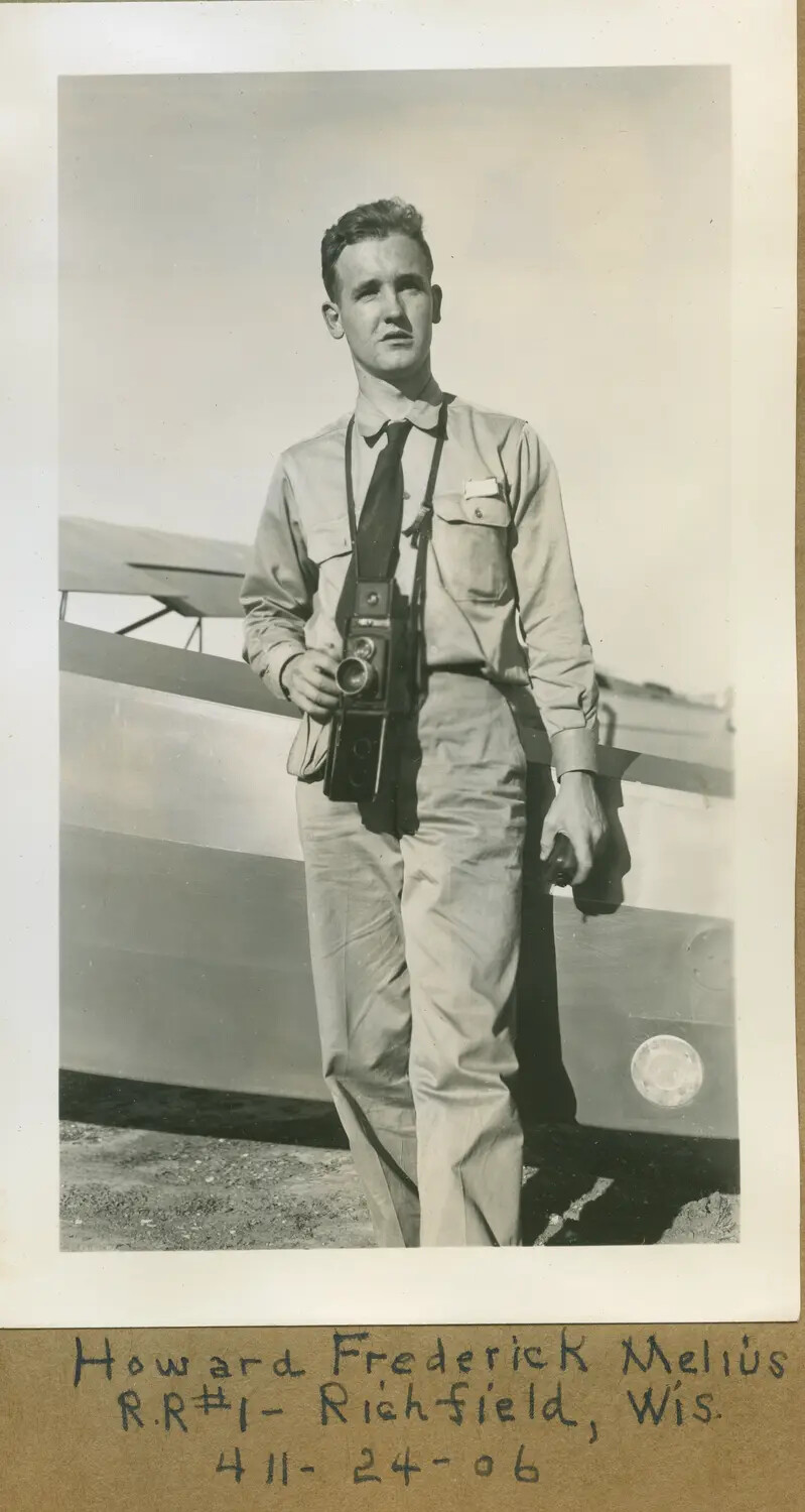 Portrait of Howard Frederick Melius with Camera Beside Light Training Aircraft