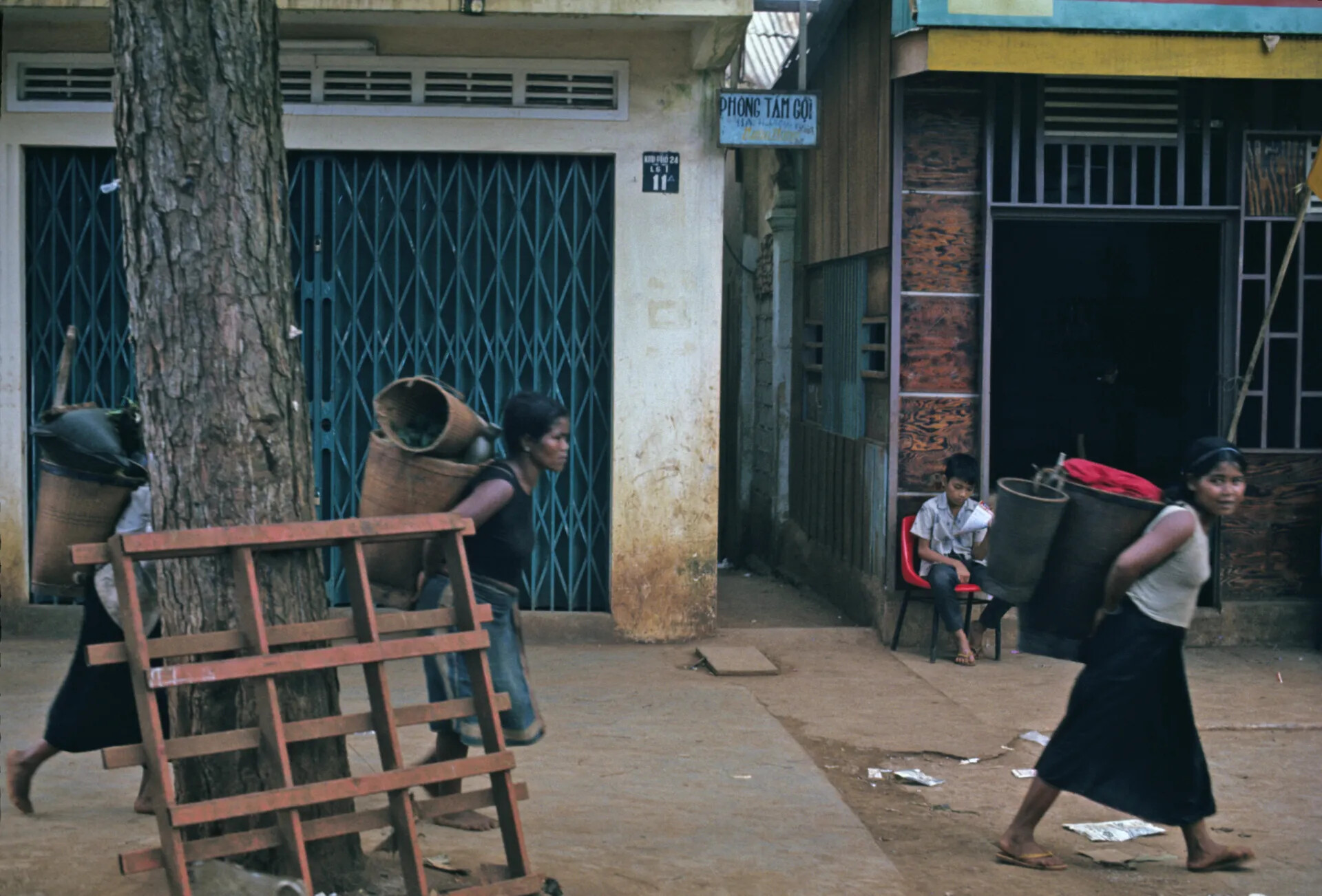 Street Scene with Basket Carriers and Storefronts, South Vietnamese Town, circa December 1969