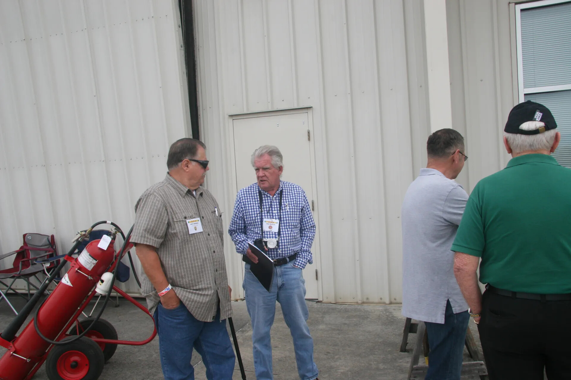 Attendees Conversing Outside Hangar Building, Reunion Event