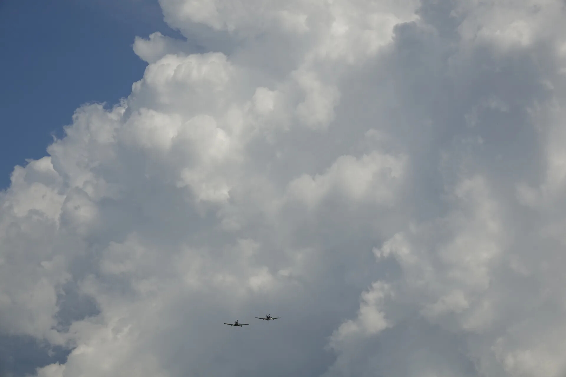 Two-Ship Warbird Formation Beneath Cumulus Clouds (Sequence Frame)
