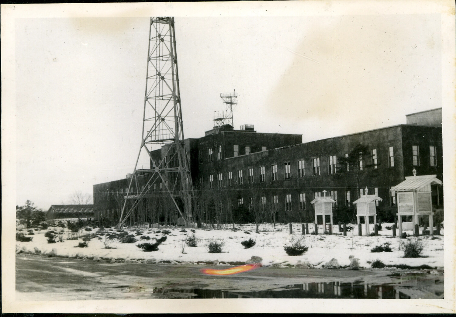 Snow-Covered Grounds with Lattice Tower, Long Institutional Building, and Weather Instrument Shelters
