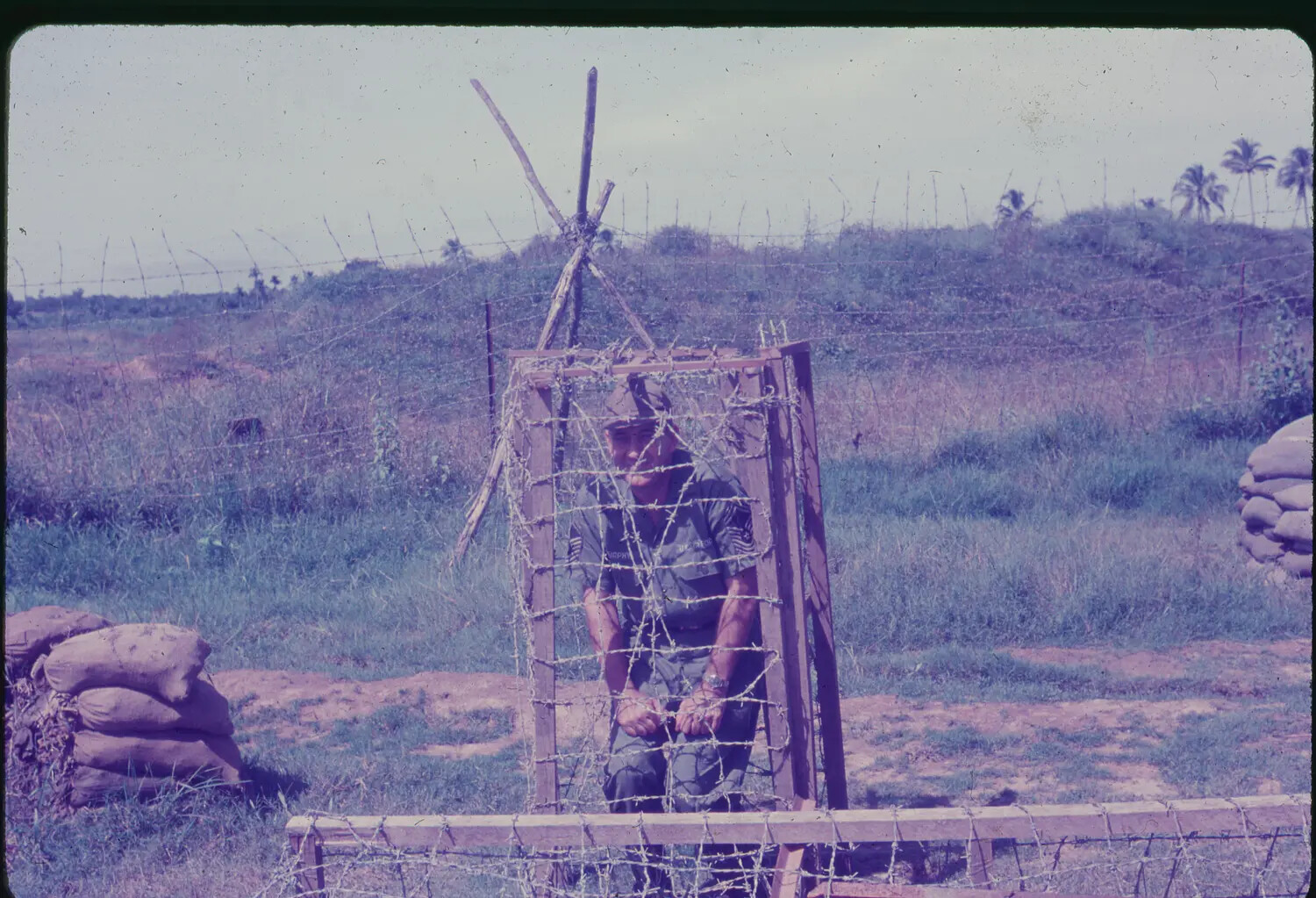 USAF NCO at Barbed-Wire Perimeter Gate, 3rd Tactical Fighter Wing, South Vietnam, 1965