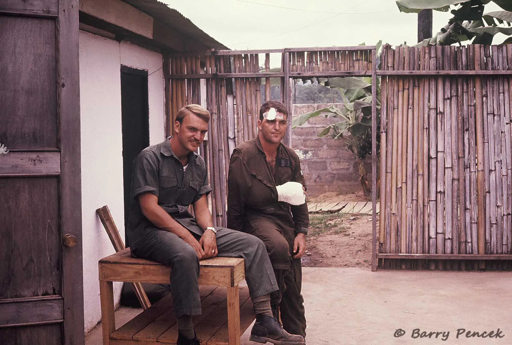 Two Servicemen at Rear Compound, One With Bandaged Injuries
