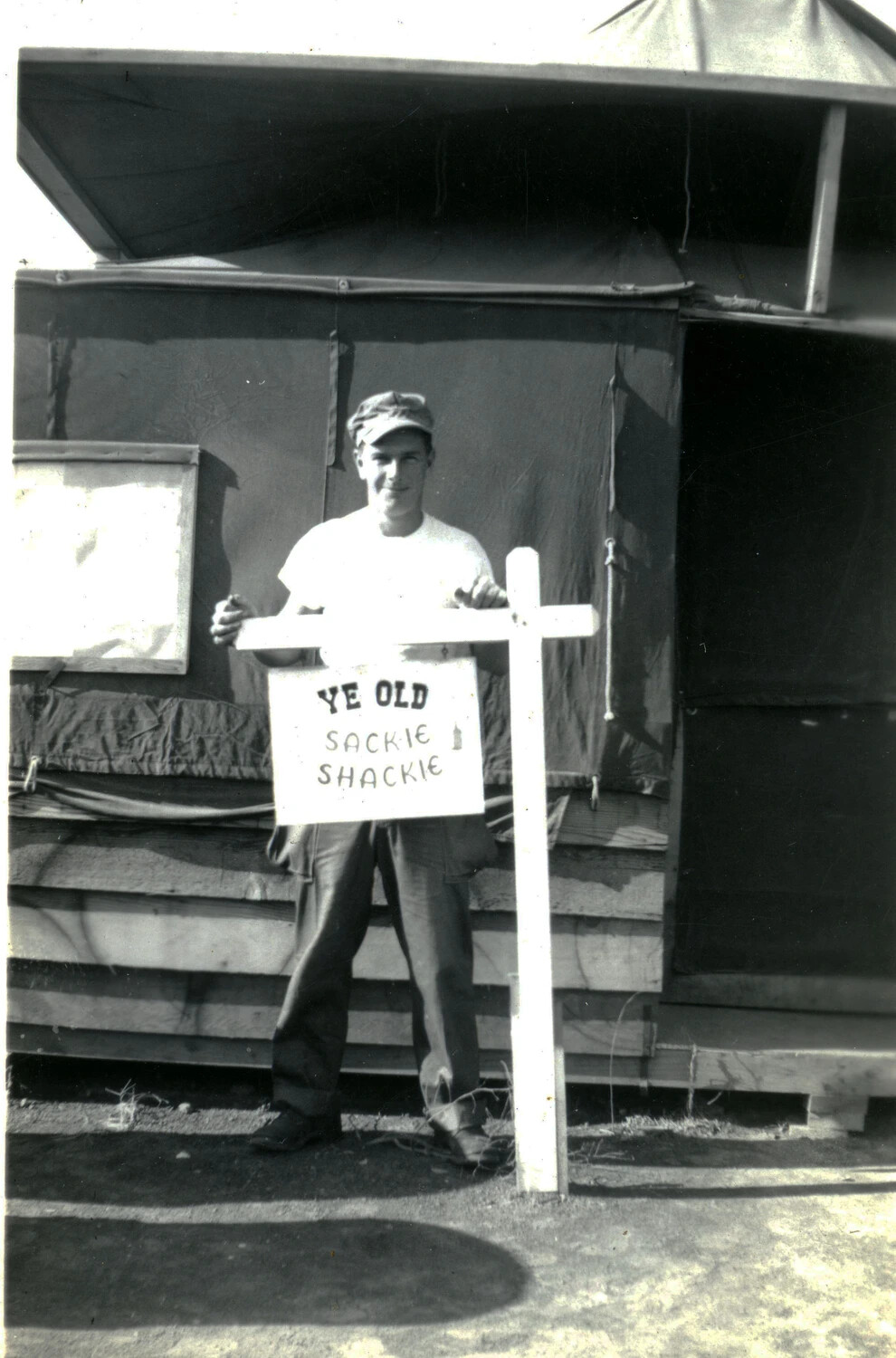 Second Marine Posing Beside 'Ye Old Sackie Shackie' Camp Sign, WWII