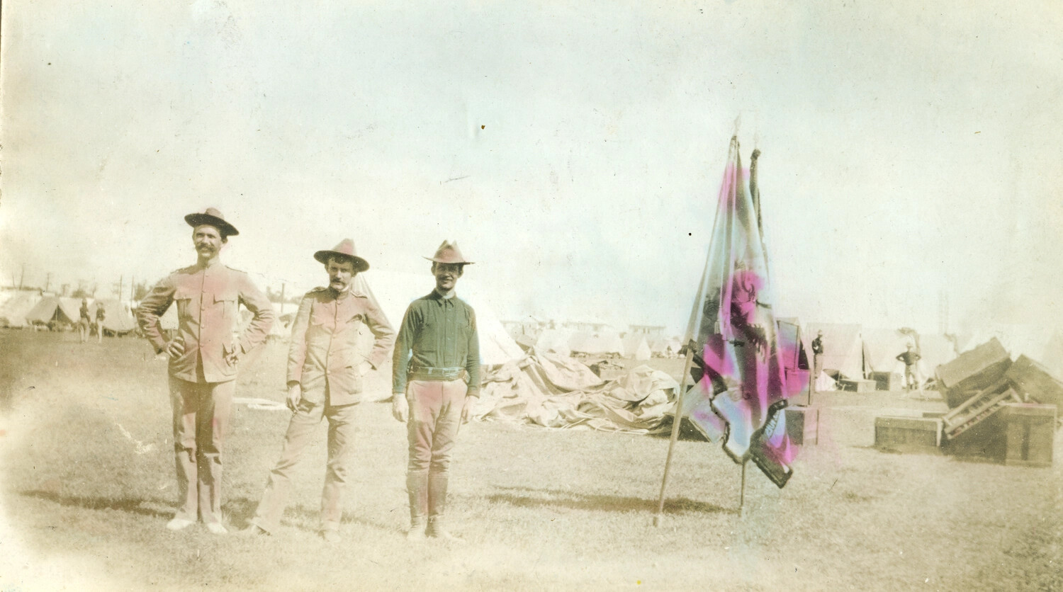 Three U.S. Army Soldiers with Company Flags at Philippine Encampment, Early 1900s — Carl Stone Collection
