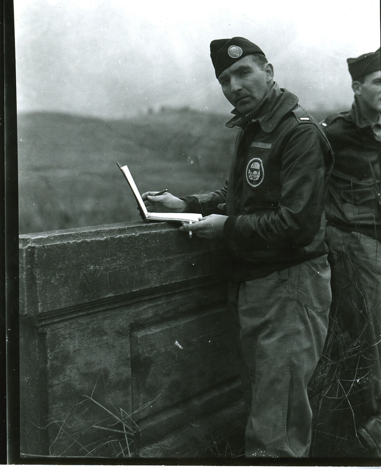 Captain Buher, 502nd Parachute Infantry Regiment, Recording Field Notes at a Stone Parapet, European Theater, WWII