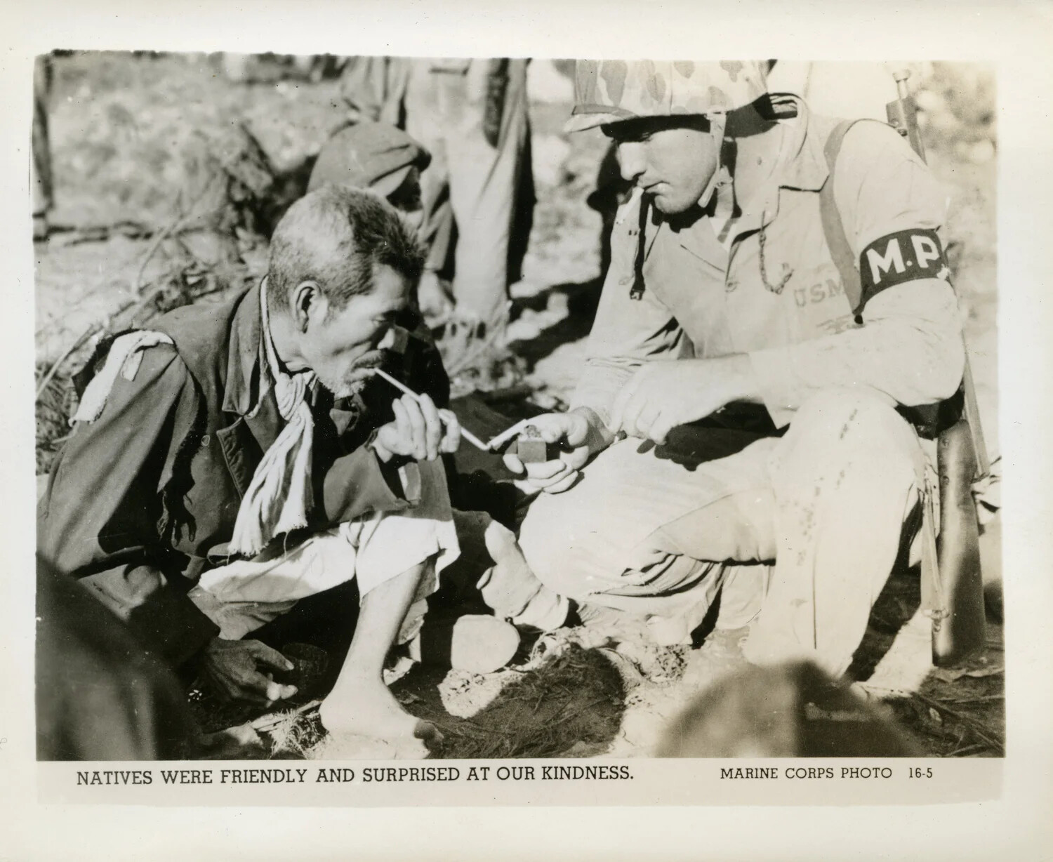 U.S. Marine Military Policeman Lights Cigarette for Elderly Okinawan Civilian, Battle of Okinawa, 1945 (Official USMC Photo 16-5)