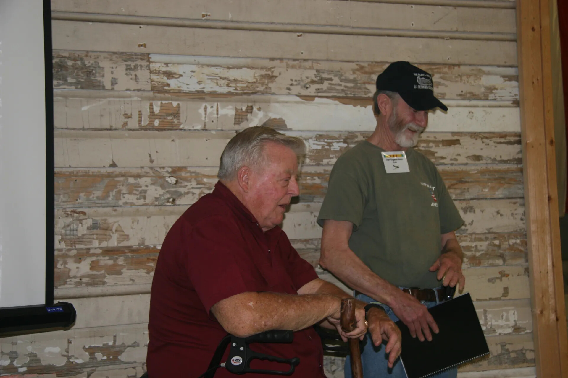Two Veterans at Indoor Reunion Gathering, A-1 Skyraider Association Cap Visible