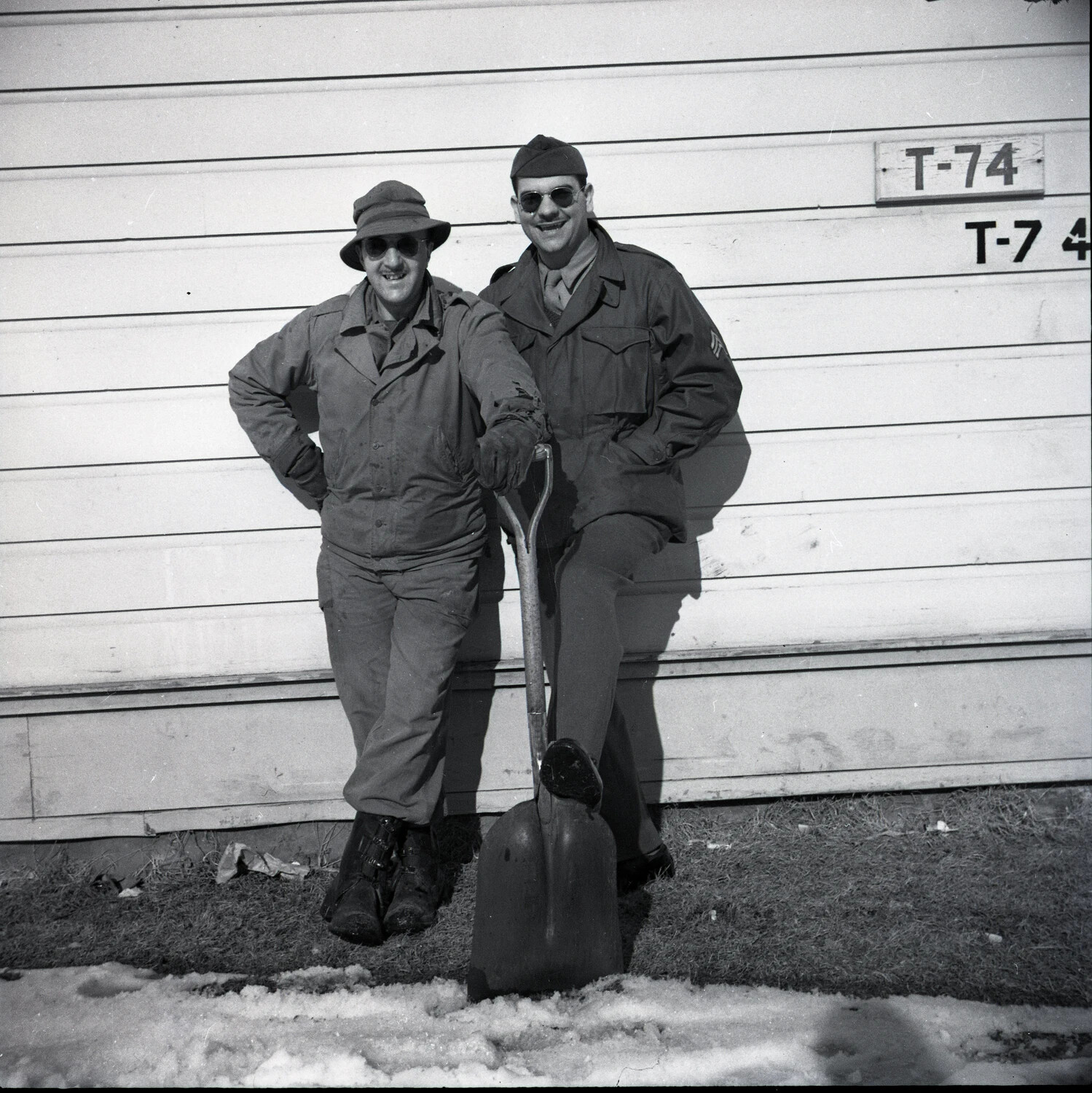 Two Servicemen Posing with Snow Shovel Beside Building T-74