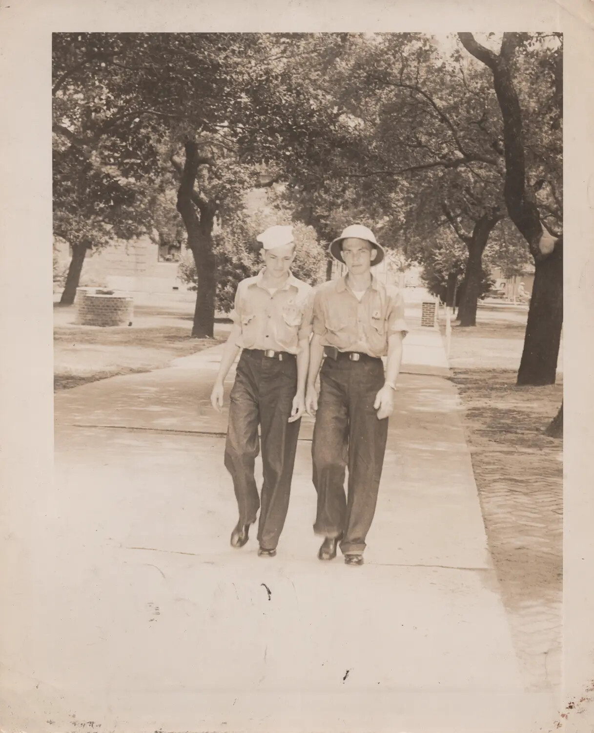 Two Young Men in Cadet-Style Summer Uniforms on Campus Walkway