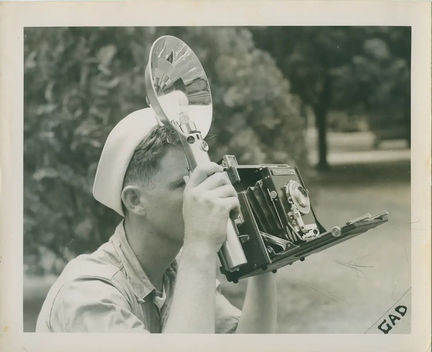 U.S. Navy Sailor Operating a Speed Graphic Press Camera, WWII Era
