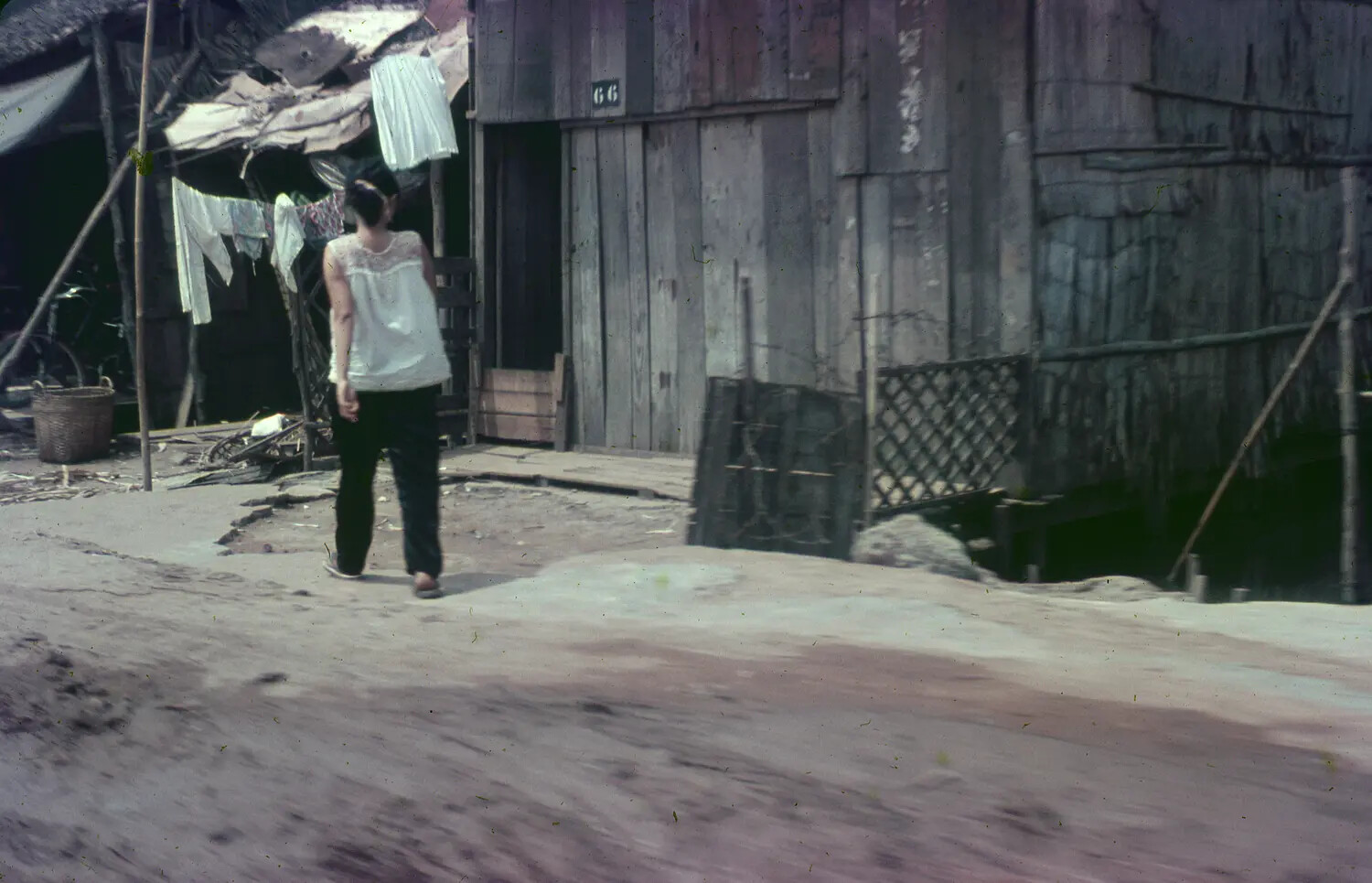 Vietnamese Woman Walking Through a Village Alley, South Vietnam, 1965