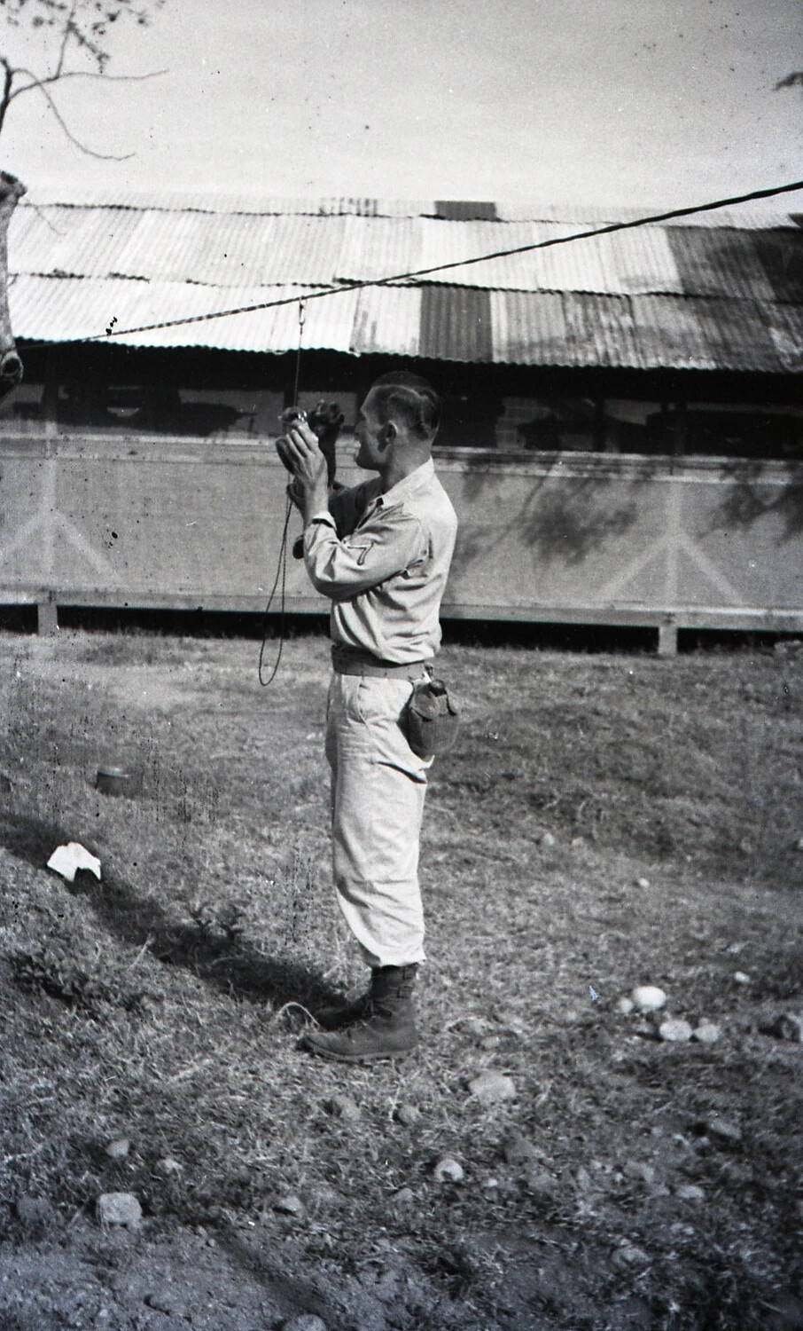 U.S. Serviceman Photographing with Handheld Camera at Luzon, Philippines Encampment, WWII
