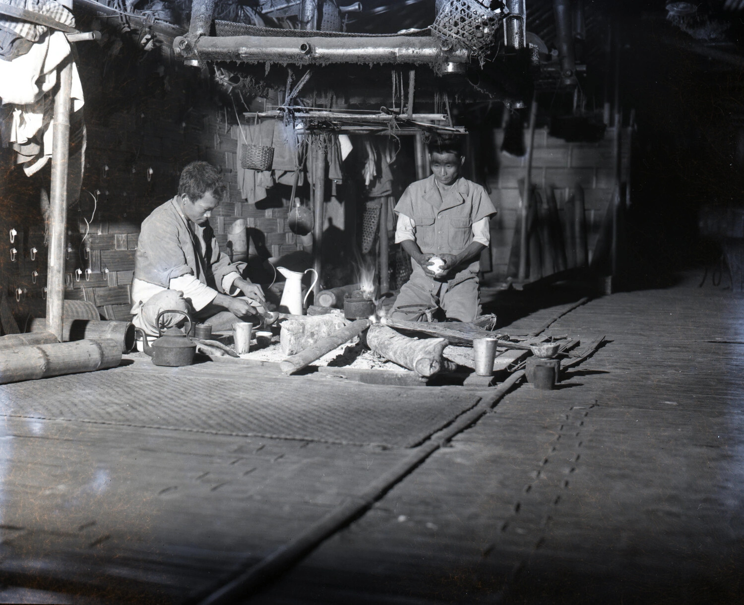 Two Burmese Men Preparing Food Over an Open Hearth in a Bamboo Dwelling, Burma, WWII Era