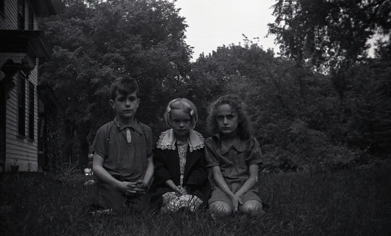 Three Children Kneeling Before a Family Home, c. 1940s