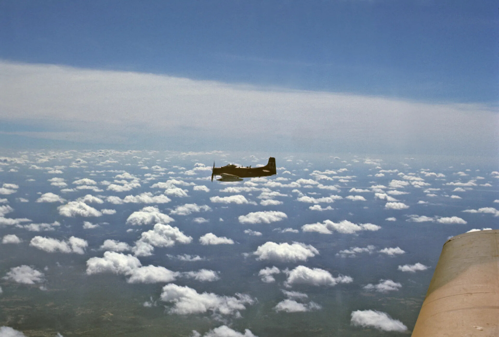 Douglas A-1 Skyraider in Cruise Over a Cumulus Deck, Air-to-Air, Southeast Asia, ca. December 1969