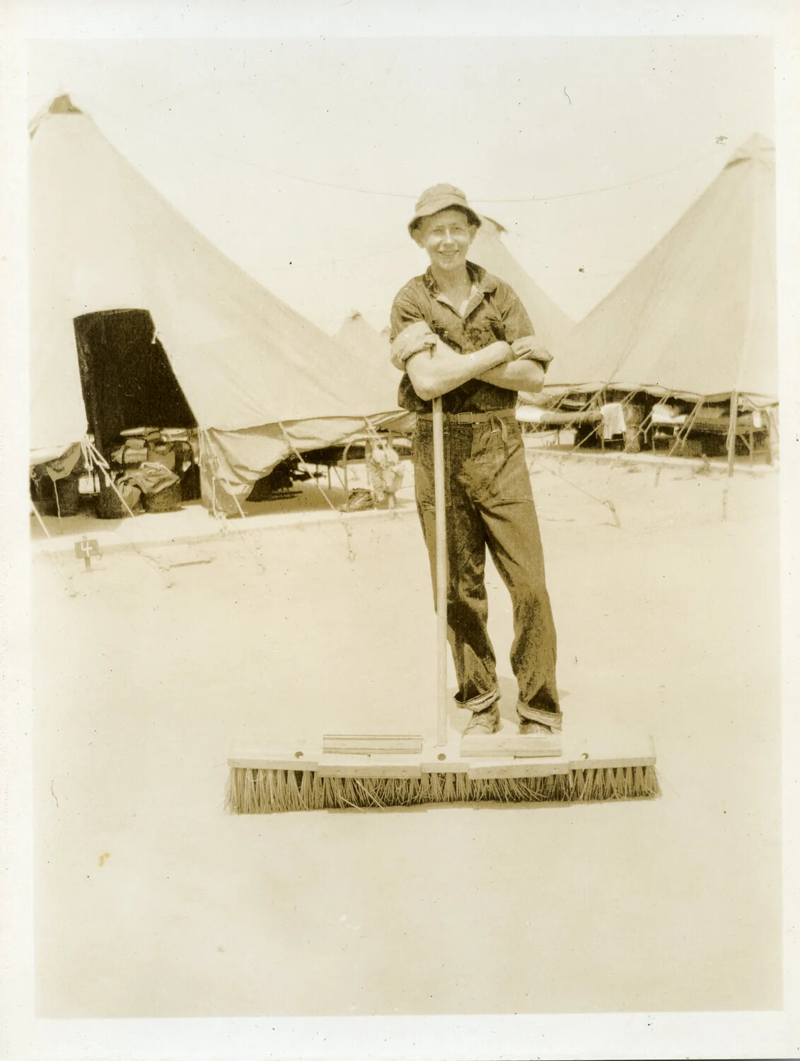 Soldier Posing on Oversized Push Broom, CBI Theater Tent Camp, WWII