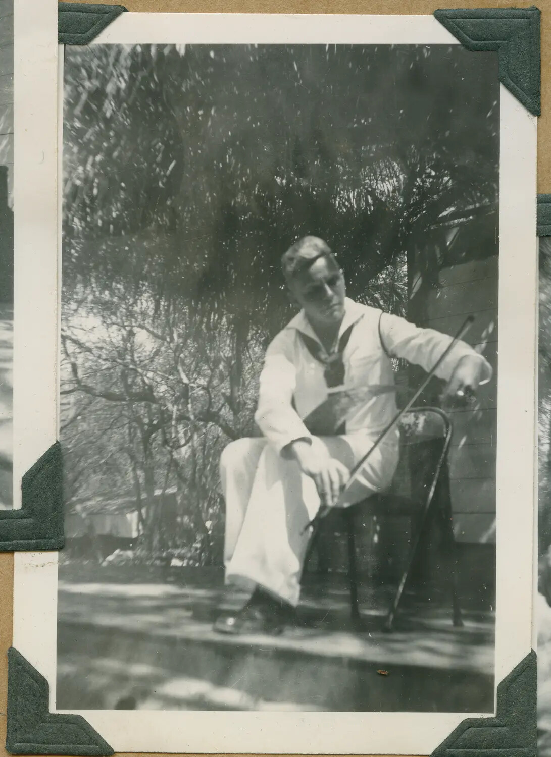 U.S. Navy Sailor in Dress Whites, Seated Outdoors, Hawaii, World War II Era
