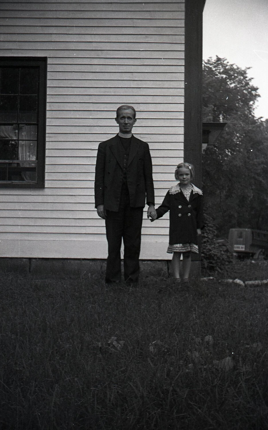 Clergyman with Young Girl Outside Farmhouse, Mid-20th Century