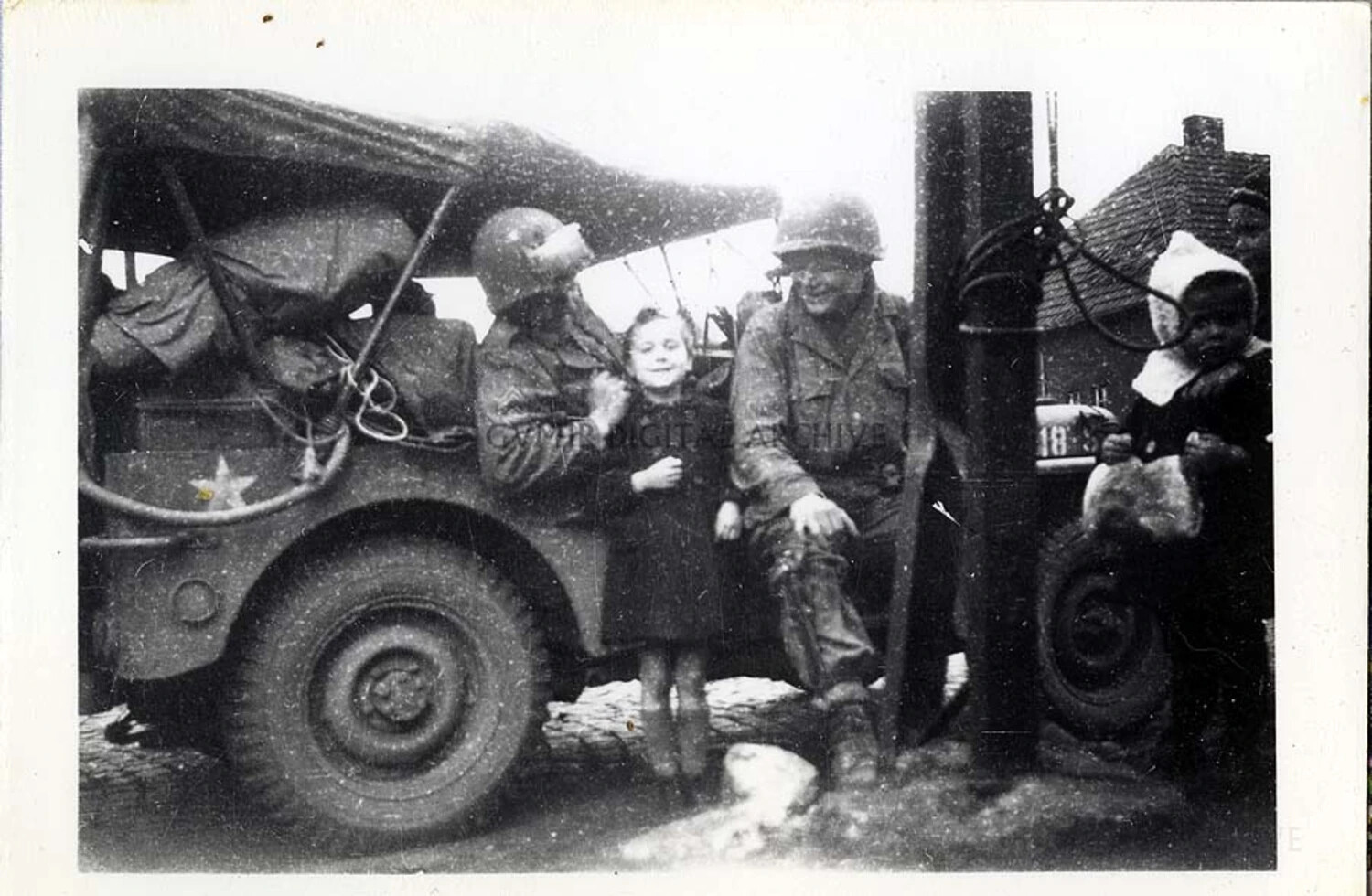 101st Airborne Division Soldiers with Local Children Beside U.S. Army Jeep, Liberated European Town, WWII