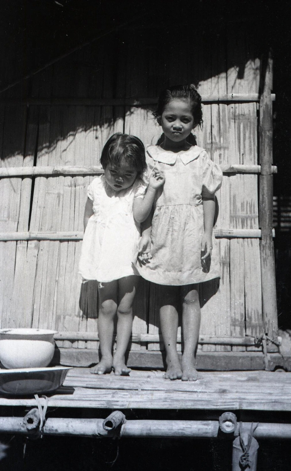 Two Young Filipino Girls on a Nipa Hut Porch, Luzon, Philippines, World War II