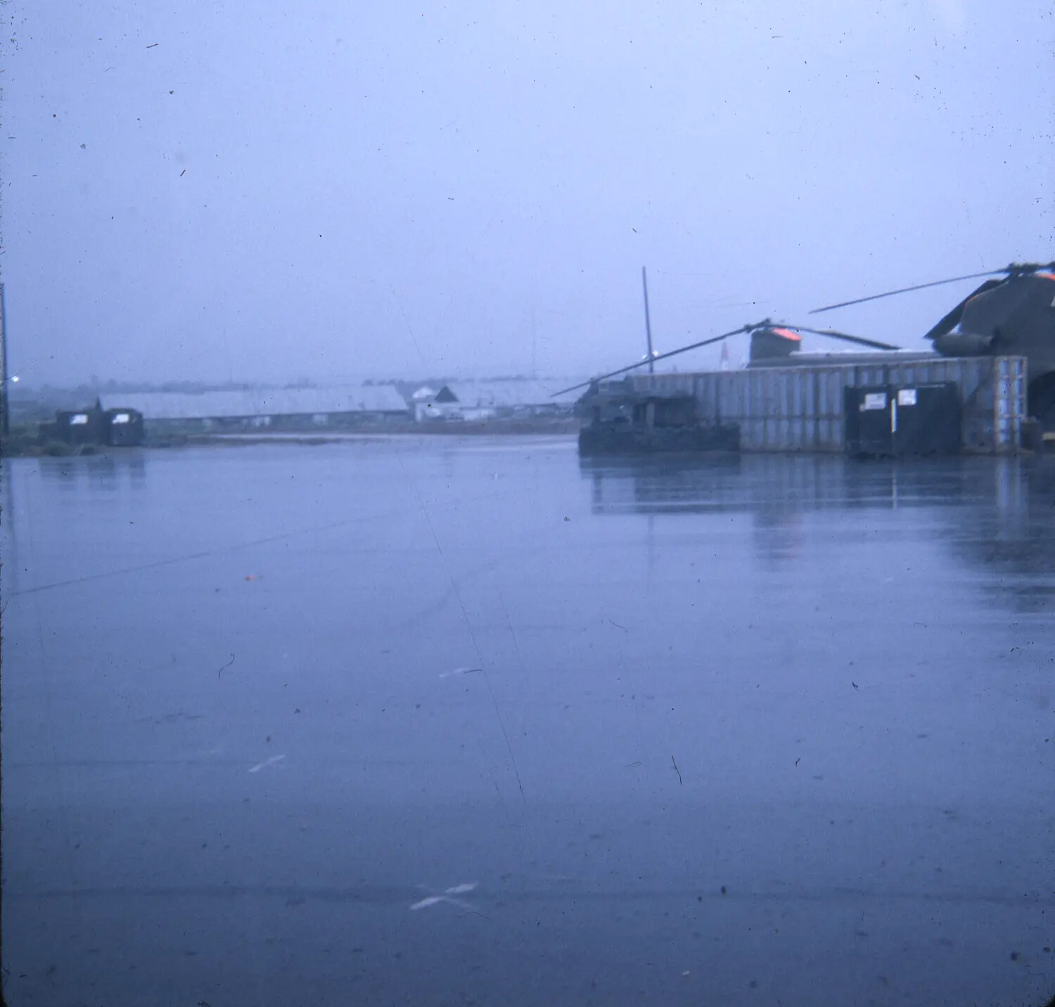 Tandem-Rotor Helicopter on Rain-Slicked Airfield, Vietnam War Era