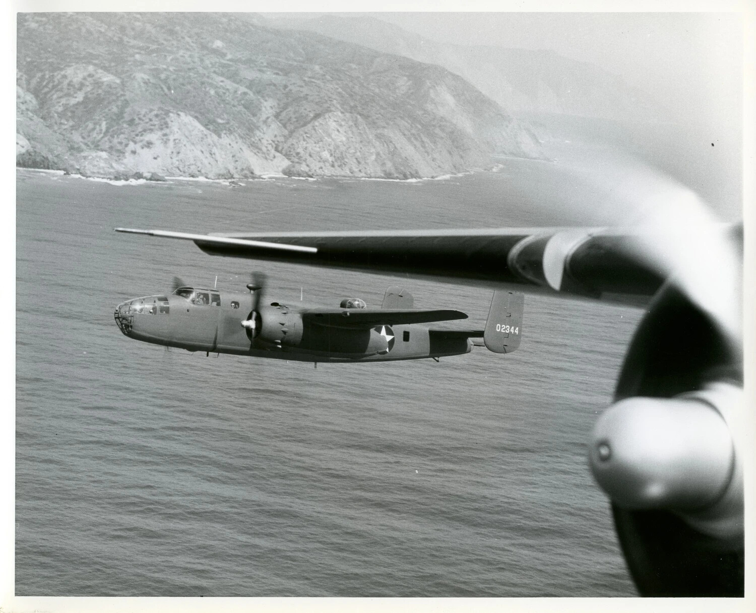 North American B-25 Mitchell Medium Bomber in Flight Over Coastal Waters, WWII-Era Air-to-Air Photograph