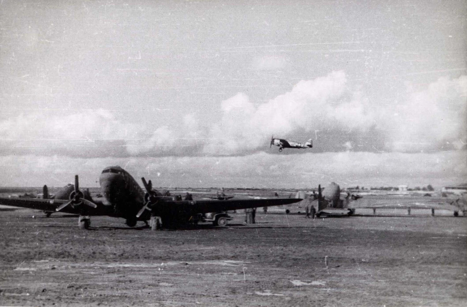 C-47 Skytrain Transports on Airfield with Overflying Liaison Aircraft, WWII European Theater