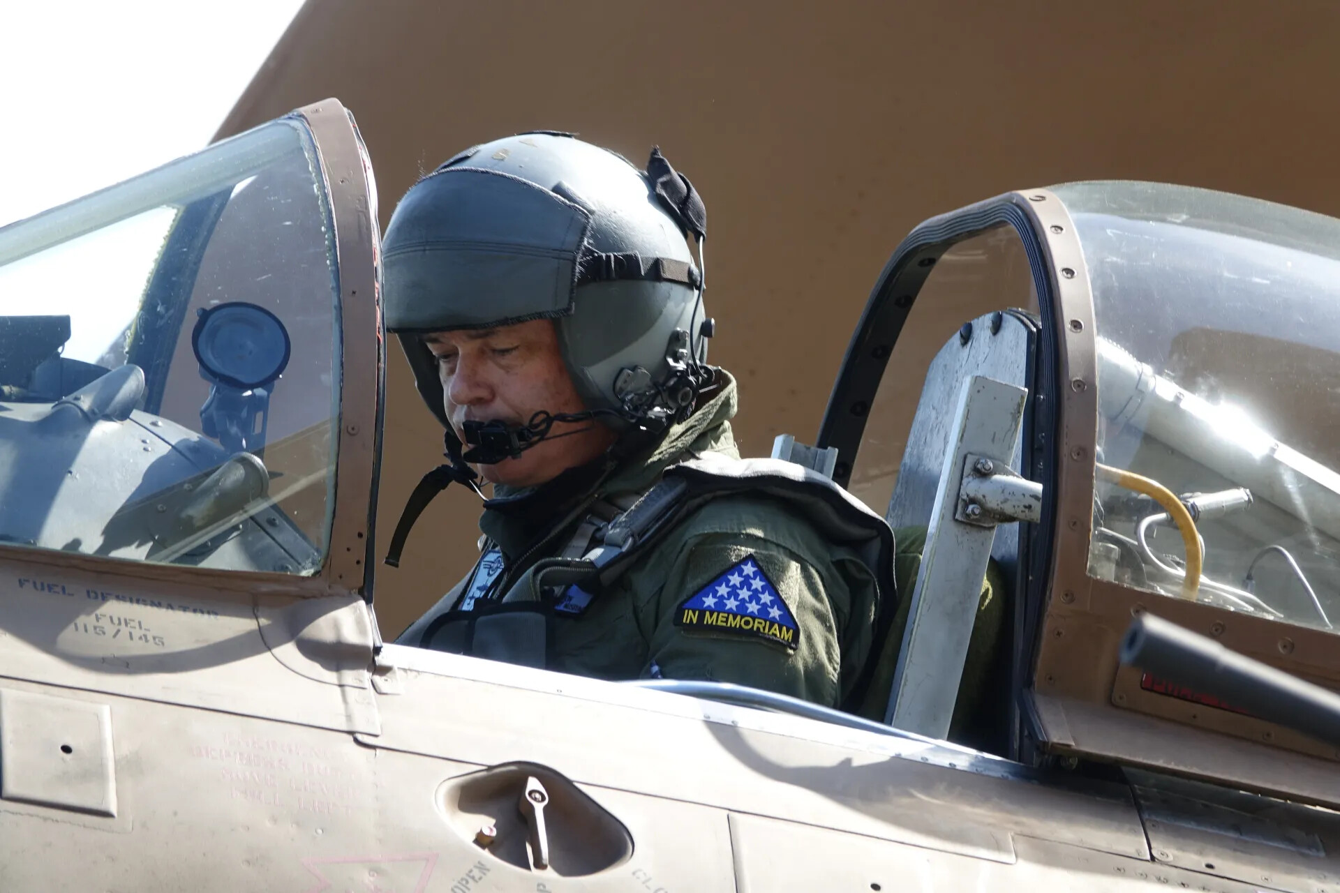 Pilot in Cockpit of Vintage A-1 Skyraider Wearing 'In Memoriam' Patch