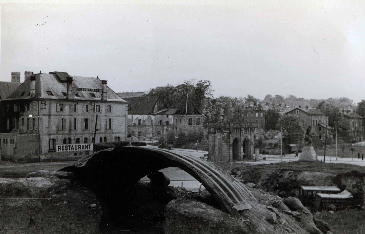 War-Damaged European Town with Collapsed Bridge and 'Hotel Tauray Restaurant,' WWII