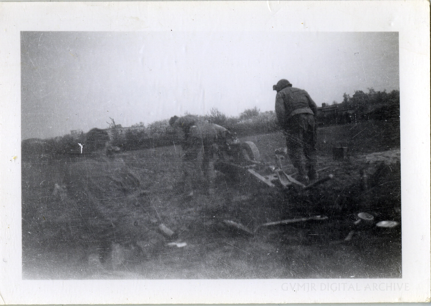 U.S. Soldiers Inspecting Abandoned Artillery Piece in Muddy Field, European Theater, WWII