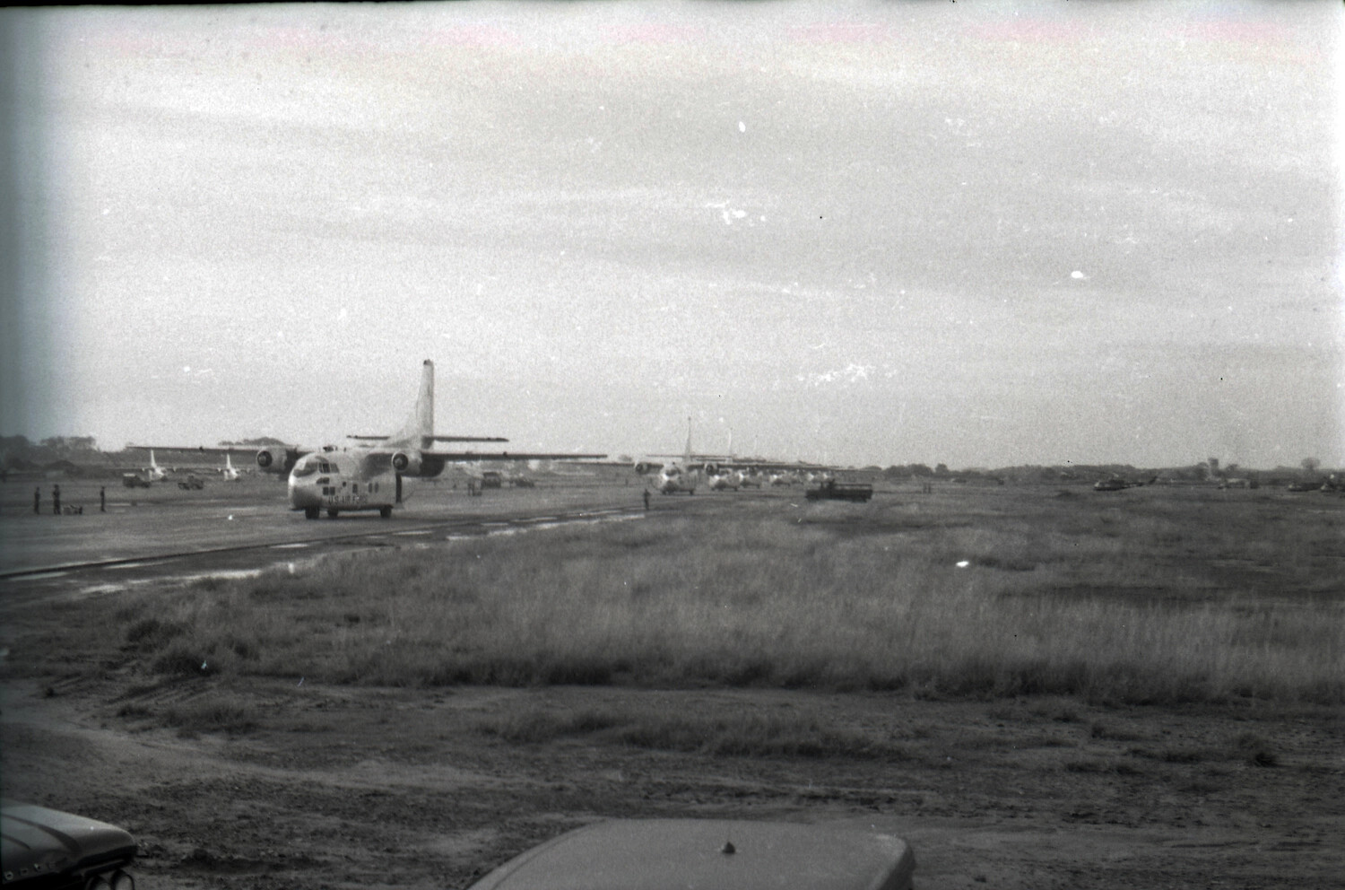 USAF C-123 Provider Transports Lined Up on Muddy Airfield Apron
