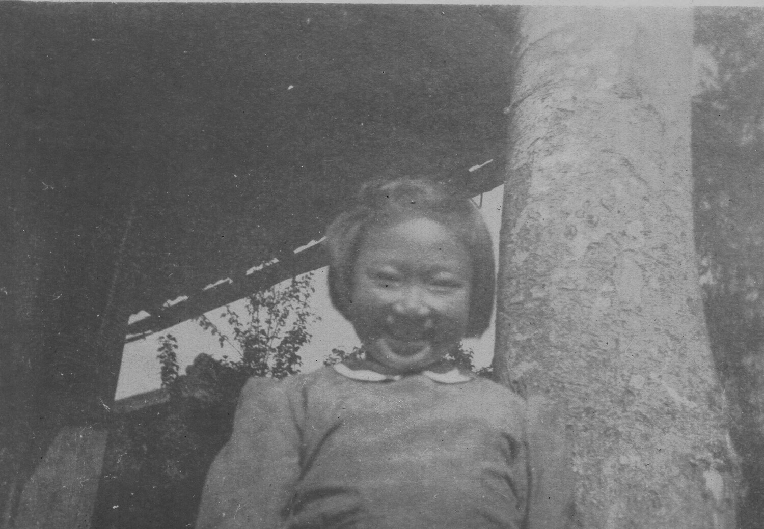 Portrait of a Laughing Young Girl Beside a Tree, Pacific Theater, WWII Era