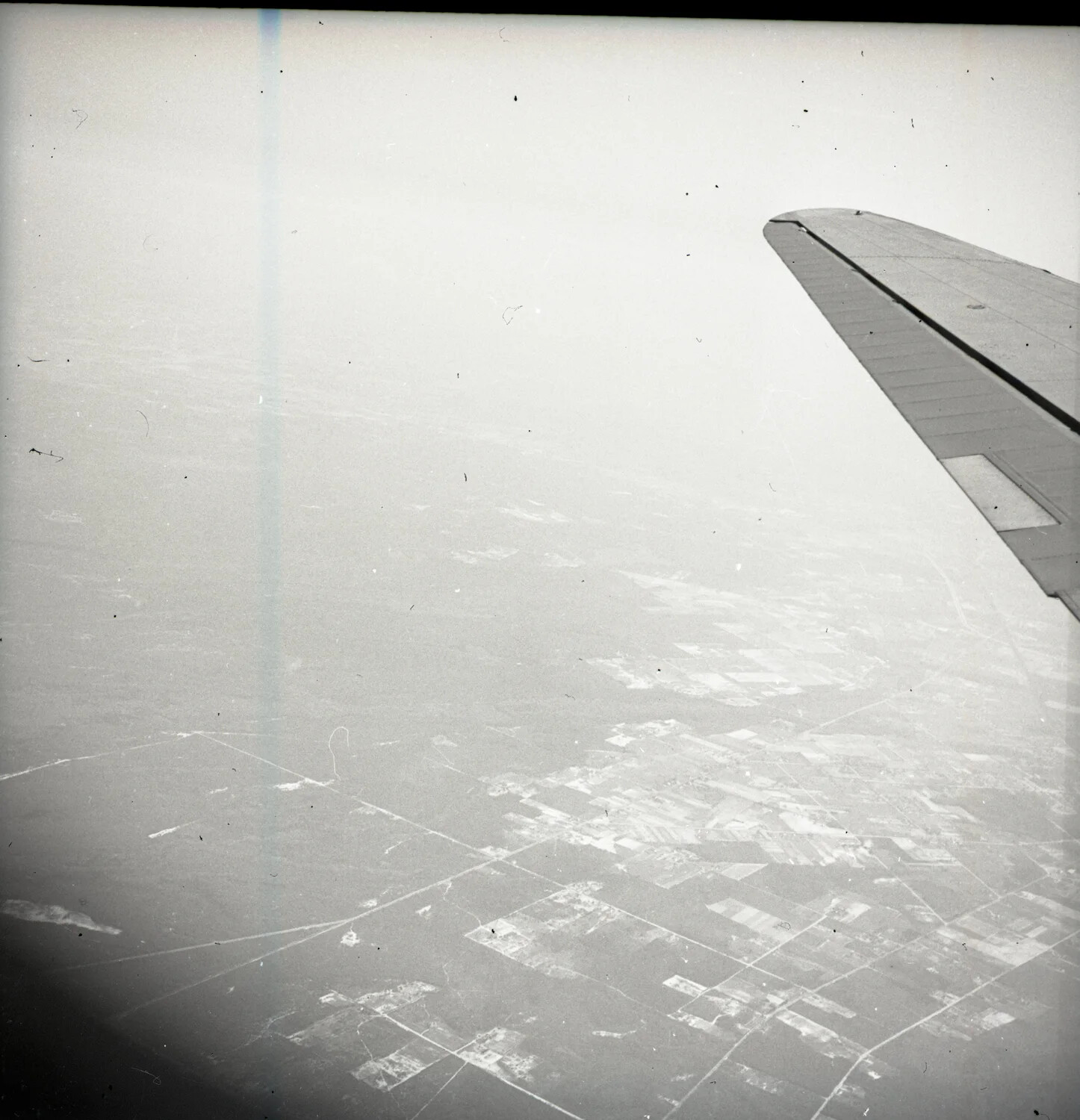 Aerial View from Aircraft Window Showing Wing and Farmland Below (Misfiled Among Military Band Negatives)