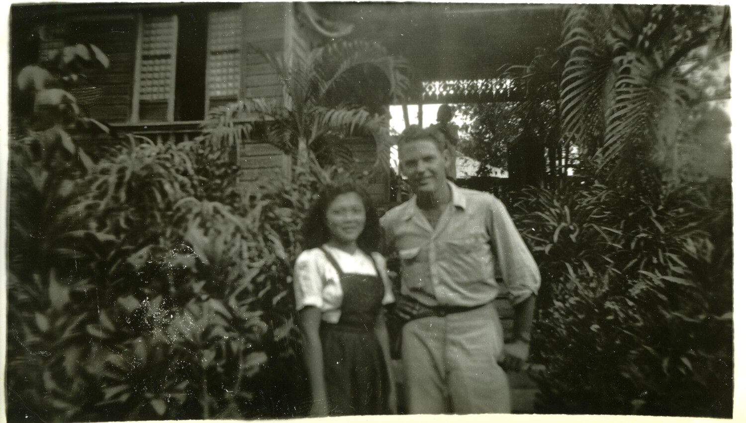 American Serviceman and Local Woman in Front of Tropical House, Pacific Theater, WWII Era