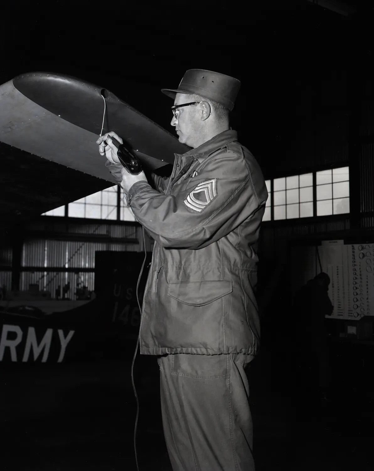 California Army National Guard NCO Servicing Cessna L-19 Bird Dog Wingtip, Sacramento Hangar