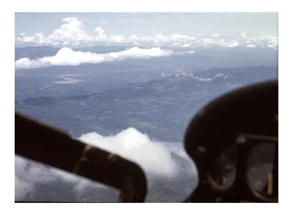 Cockpit View of Mountainous Terrain with Possible Smoke Plume, Vietnam Highlands