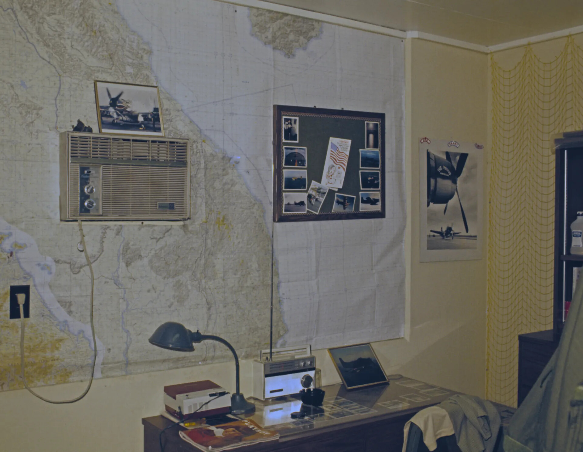 Personal Den Wall Decorated with Aeronautical Chart, Memento Board, and 'The Proud American' Squadron Poster