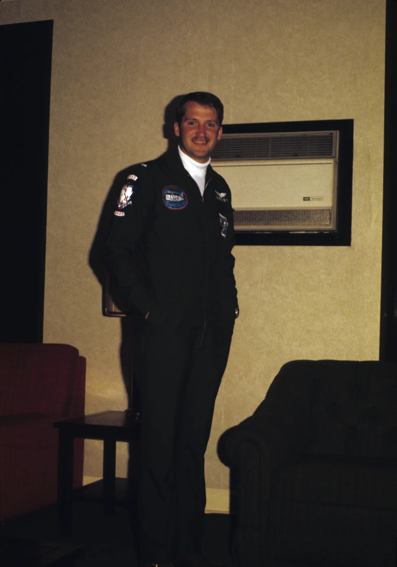 Portrait of Man in Squadron Jacket at Indoor Gathering