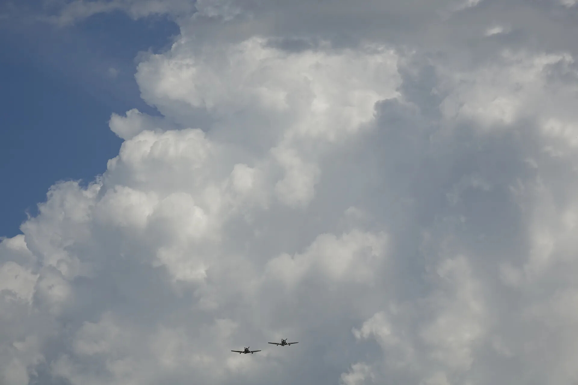 Formation Flypast of Warbird Aircraft Beneath Cumulus Clouds