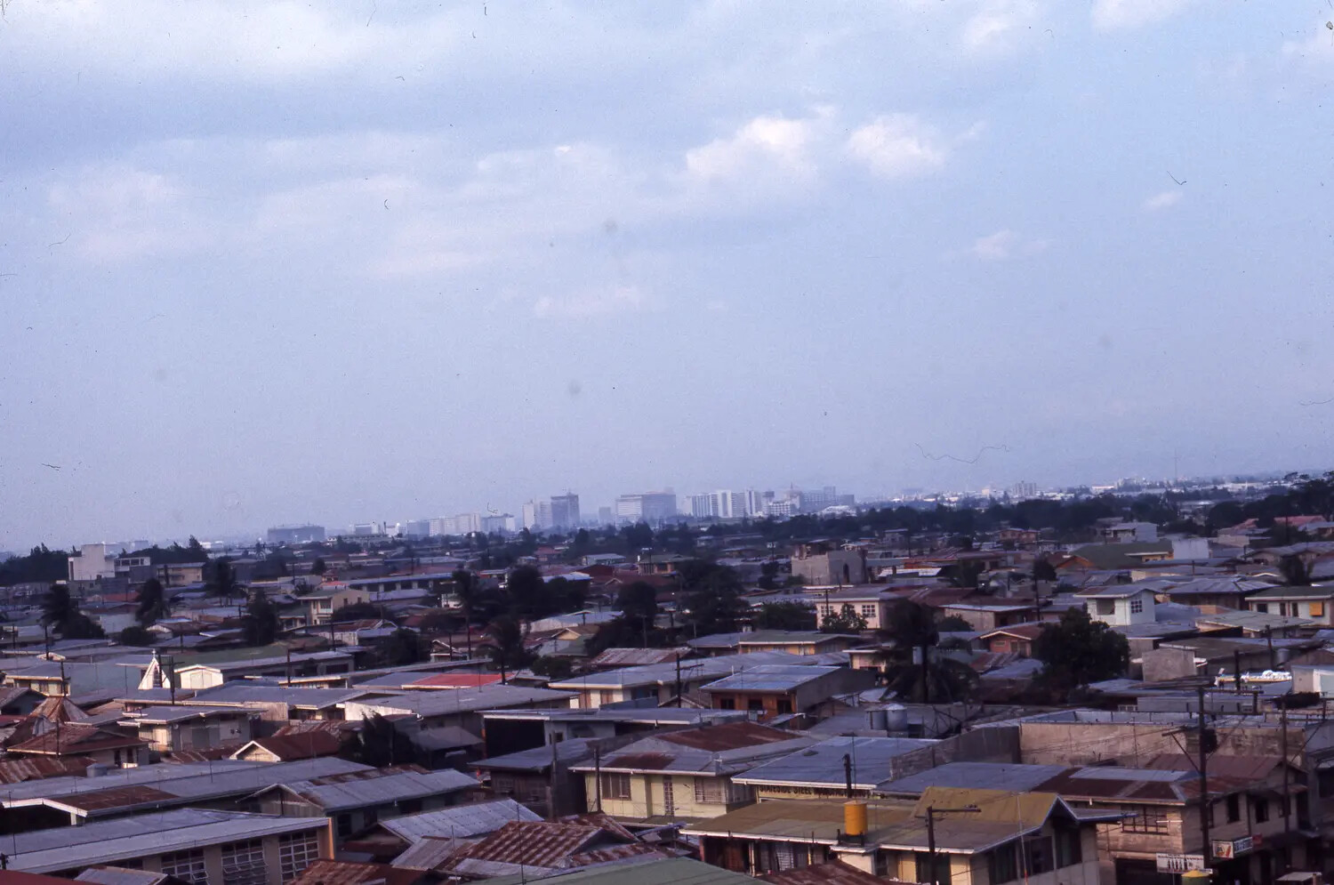 Elevated City View with Residential Rooftops and Distant Skyline, Likely Manila