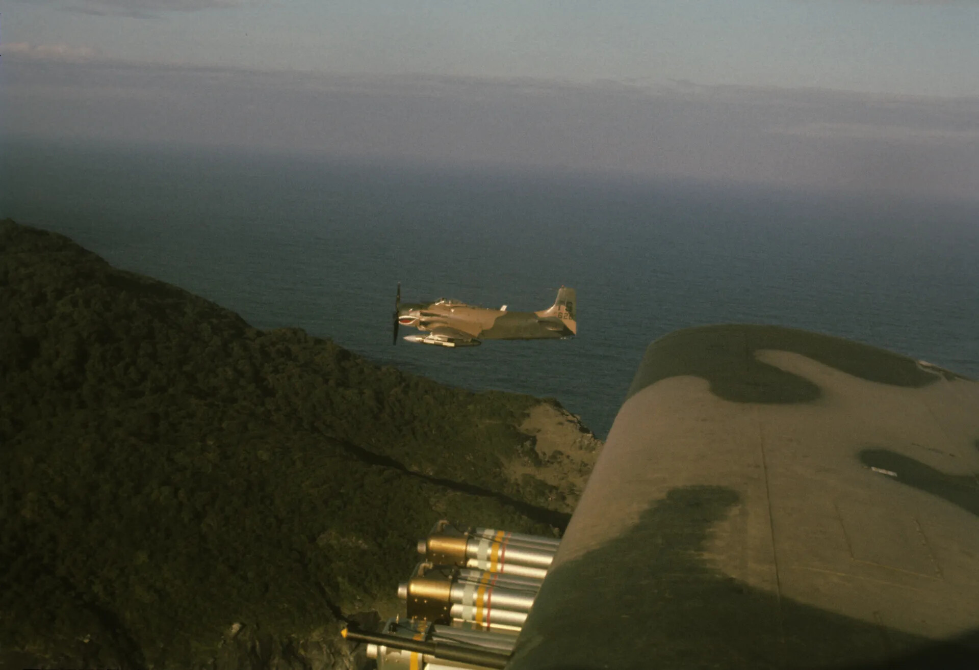 A-1 Skyraider Banking Along a Rocky Coastline